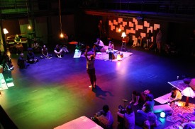 People surround a performer in the center of the von der Heyden Studio Theater